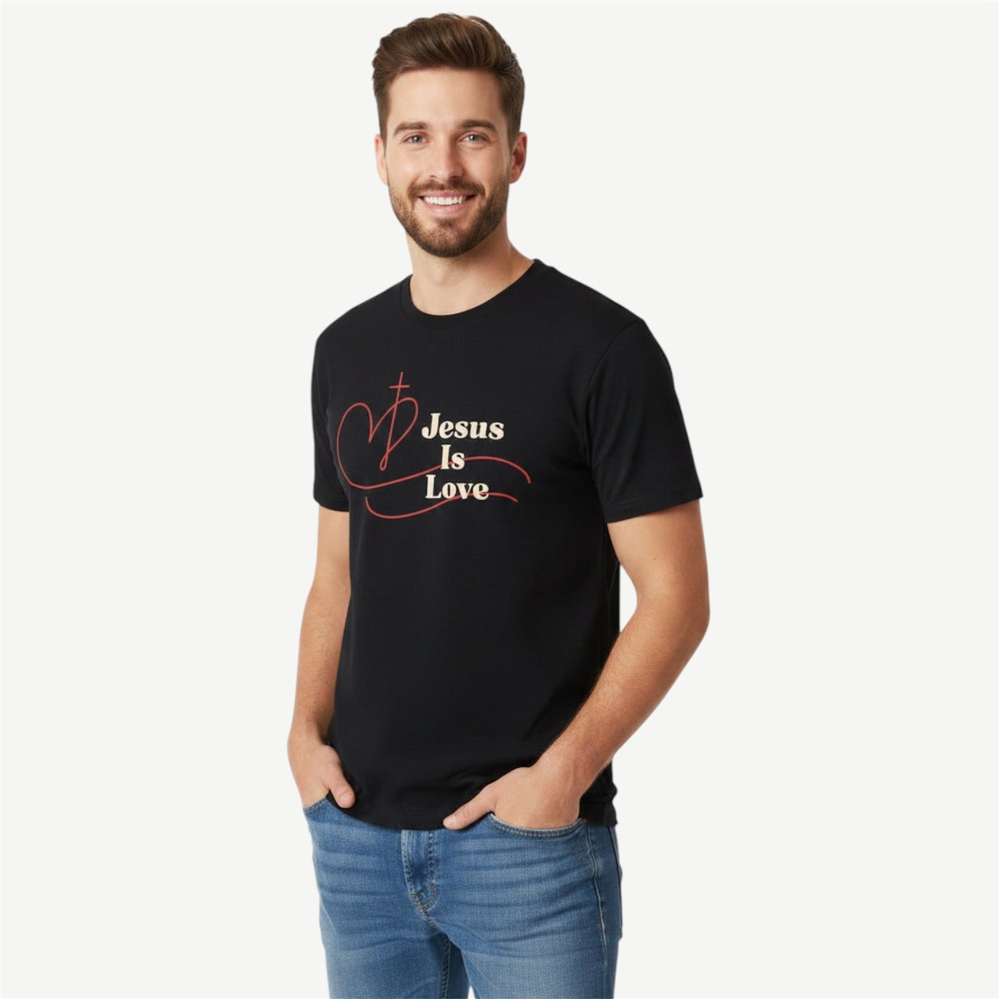 A man wearing a black short-sleeve t-shirt with a graphic that reads 'Jesus Is Love' in beige, and a red heart design, paired with blue jeans, against a light gray background.