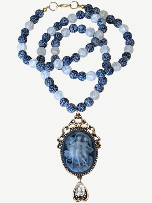 A beaded necklace featuring blue and white beads, with a large oval cameo pendant.