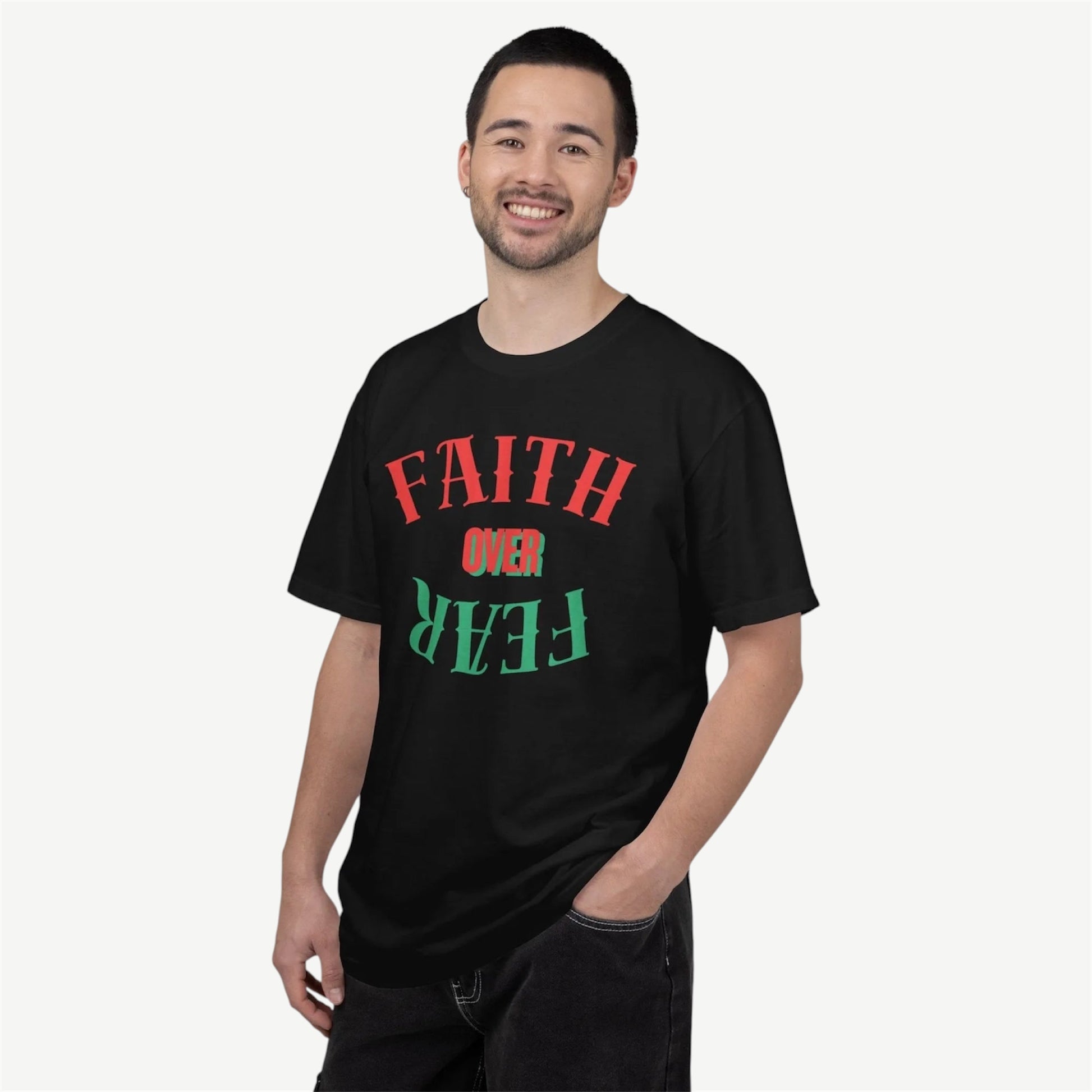 A man wearing a black t-shirt with a red and green graphic text design that reads 'FAITH OVER FEAR' on a light gray background.